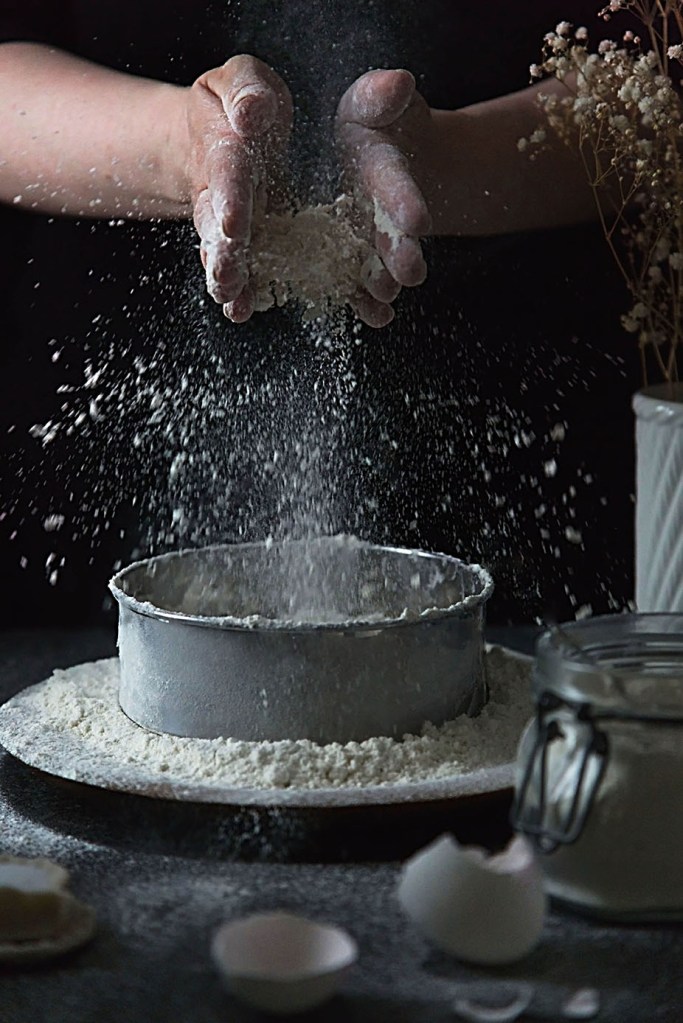 Hands in frame, action shot with flour bursting everywhere. 