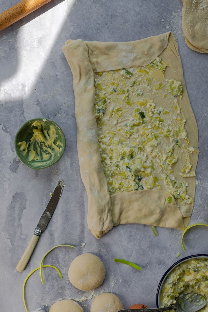 Process photo on how to roll out homemade filo pastry sheet.