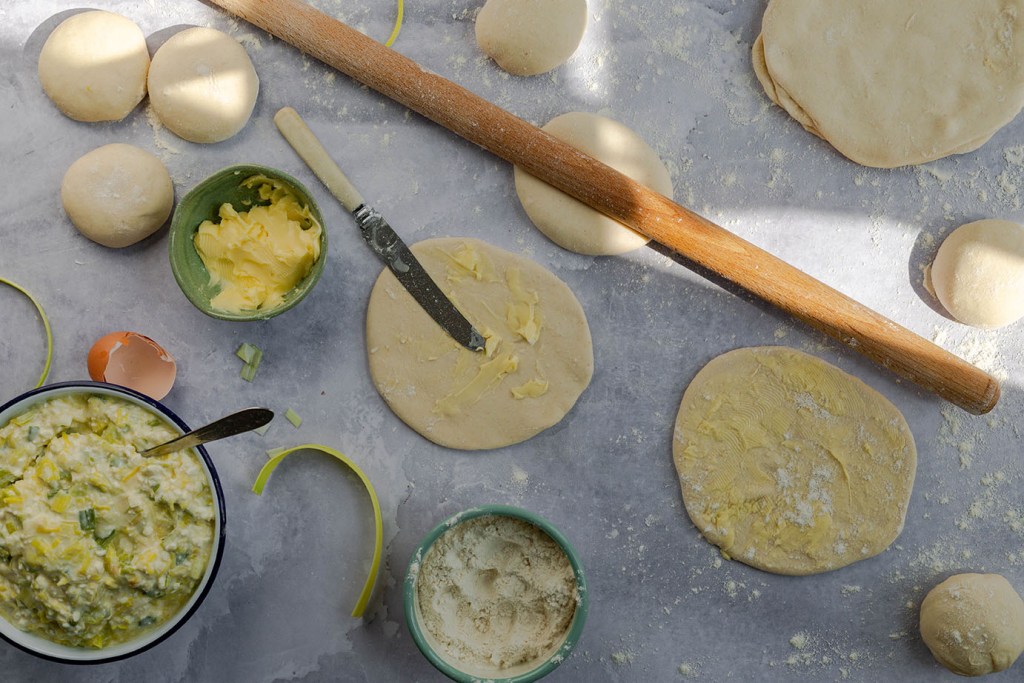 Process photo on how to roll out homemade filo pastry sheet.