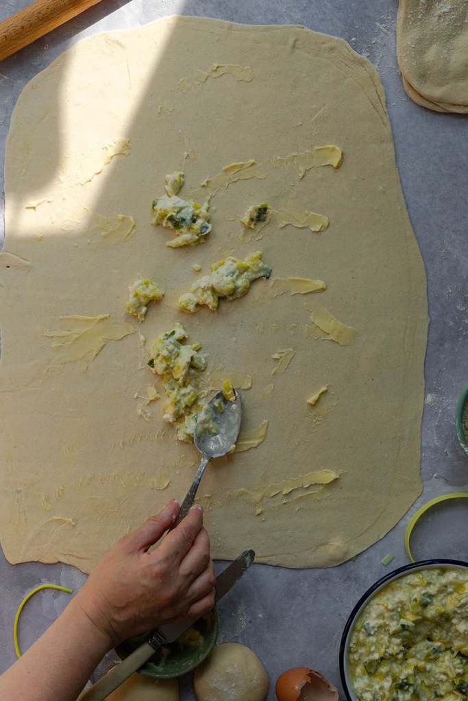 Process photo on how to roll out homemade filo pastry sheet.