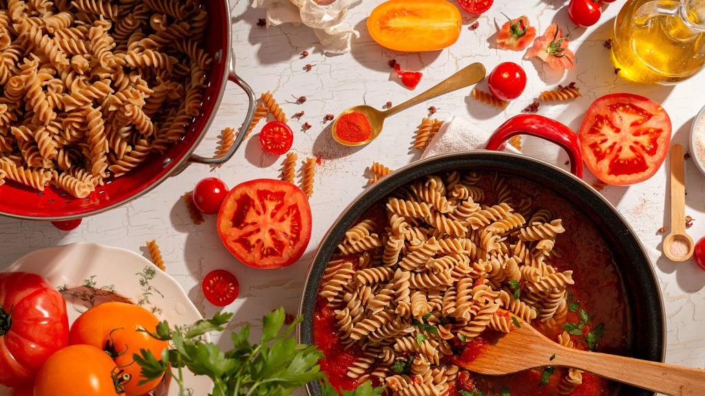 Healthy Fresh Tomato and Feta Cheese Pasta Sauce for Wholemeal Pasta, mixing pasta with the sauce.