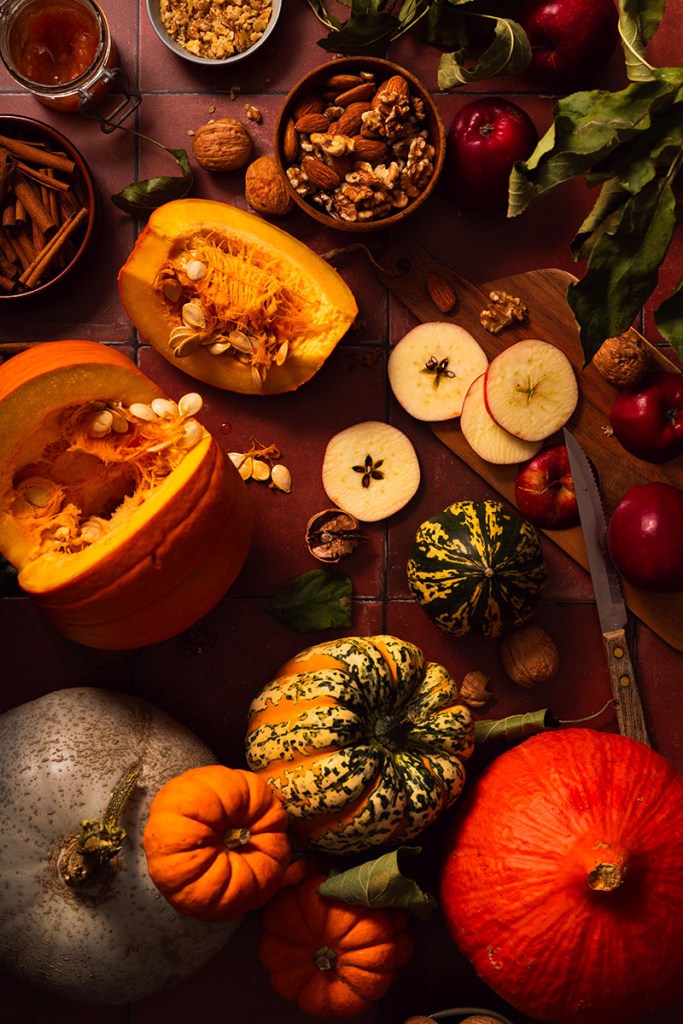 Autumn scene with squash,pumpkins, apples, walnuts on the dark brown background. 